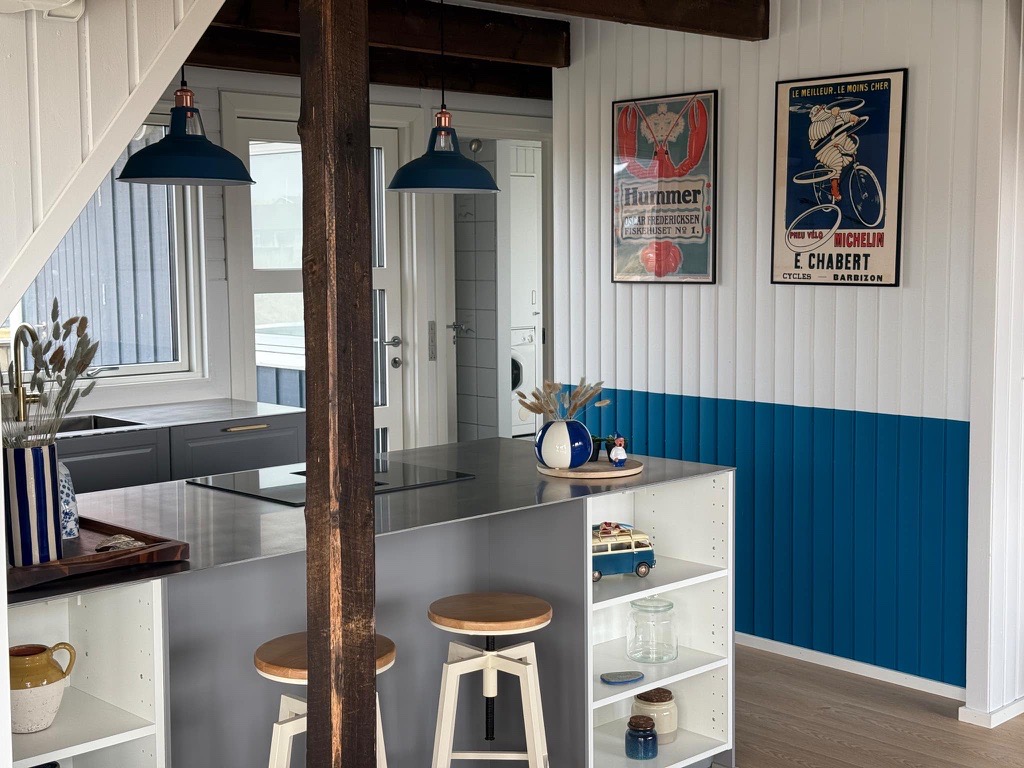 Stålø med integreret induktionskogeplade i et strandhus med synlige træbjælker